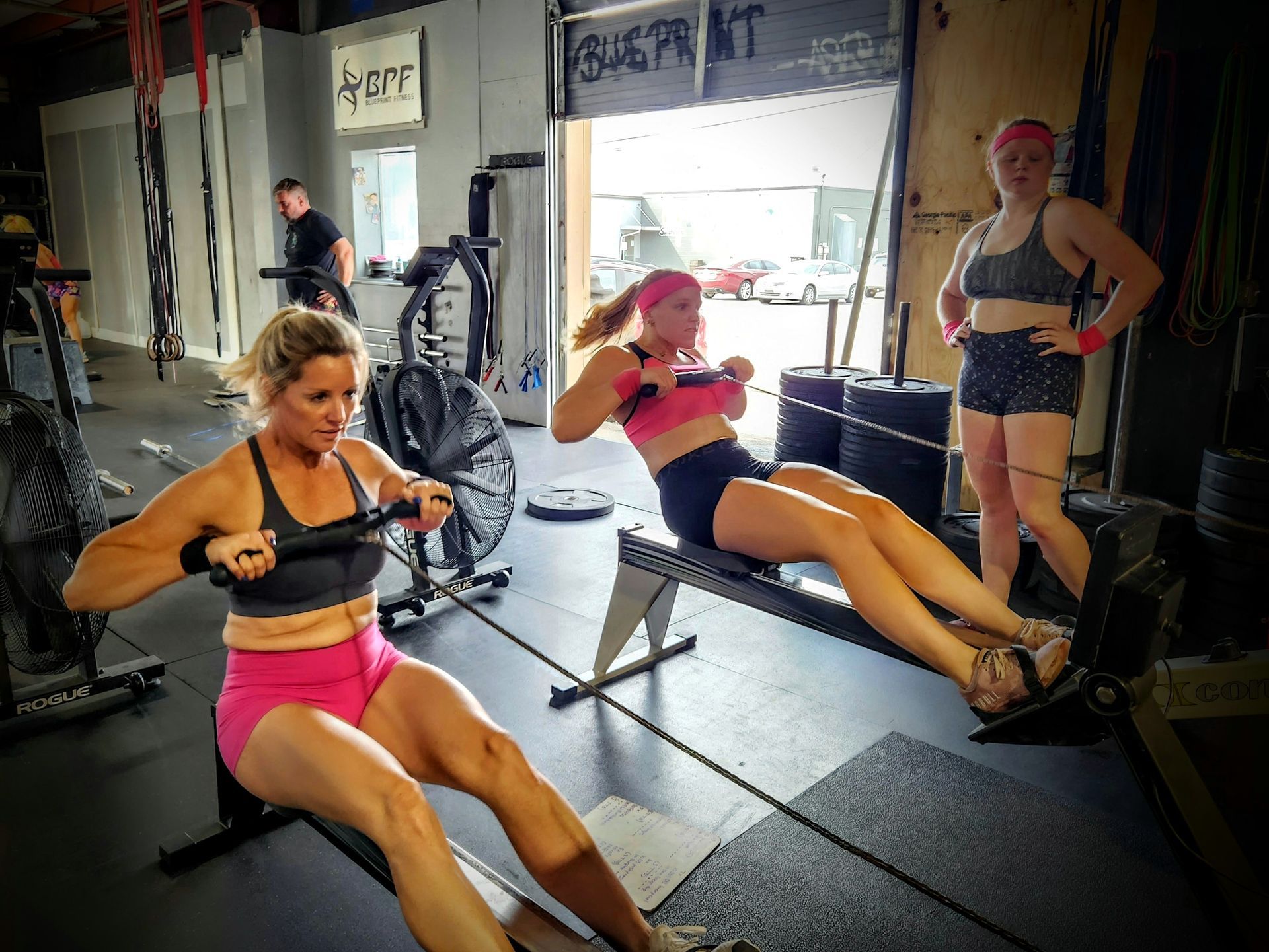 A group of women are rowing in a gym.
