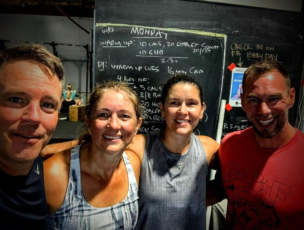 A group of people are posing for a picture in front of a blackboard.