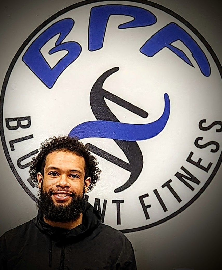 A man with a beard is smiling in front of a bf fitness logo