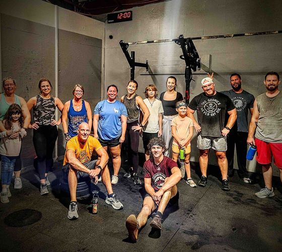 A group of people are posing for a picture in a gym.