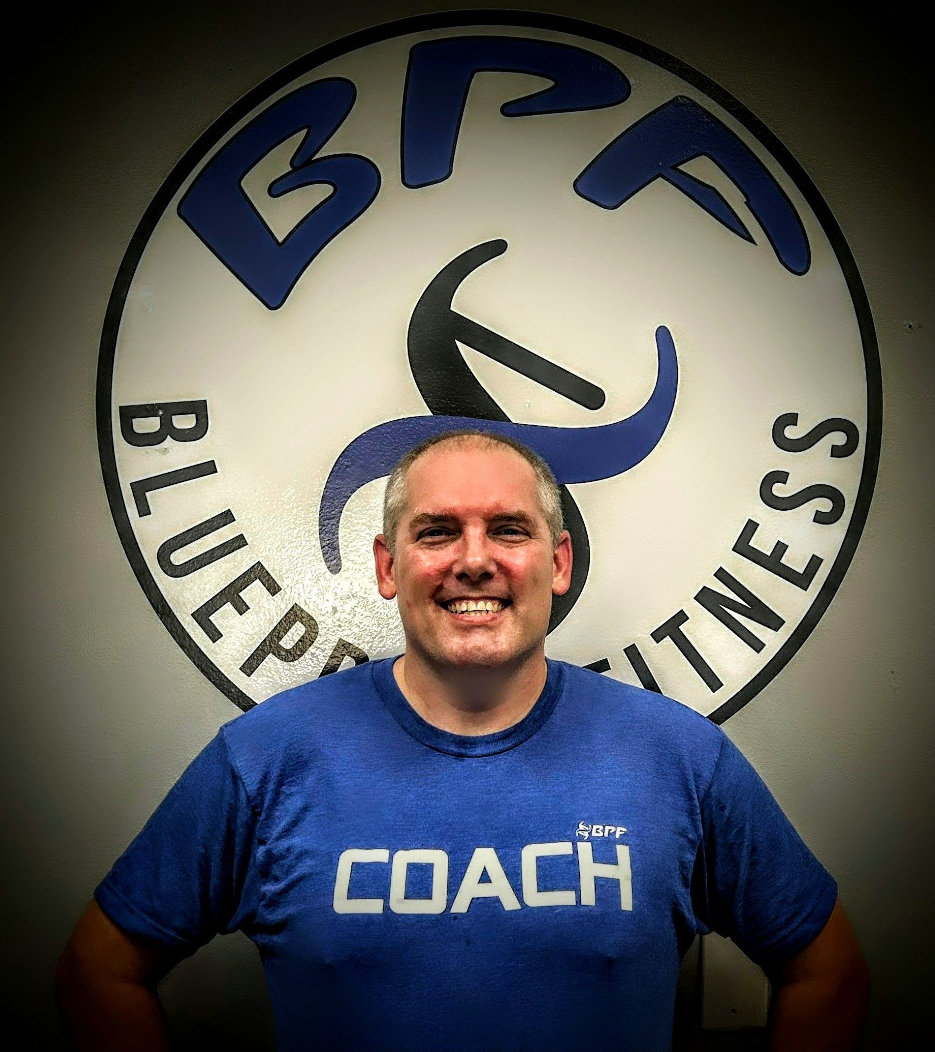 A man wearing a blue shirt that says coach on it