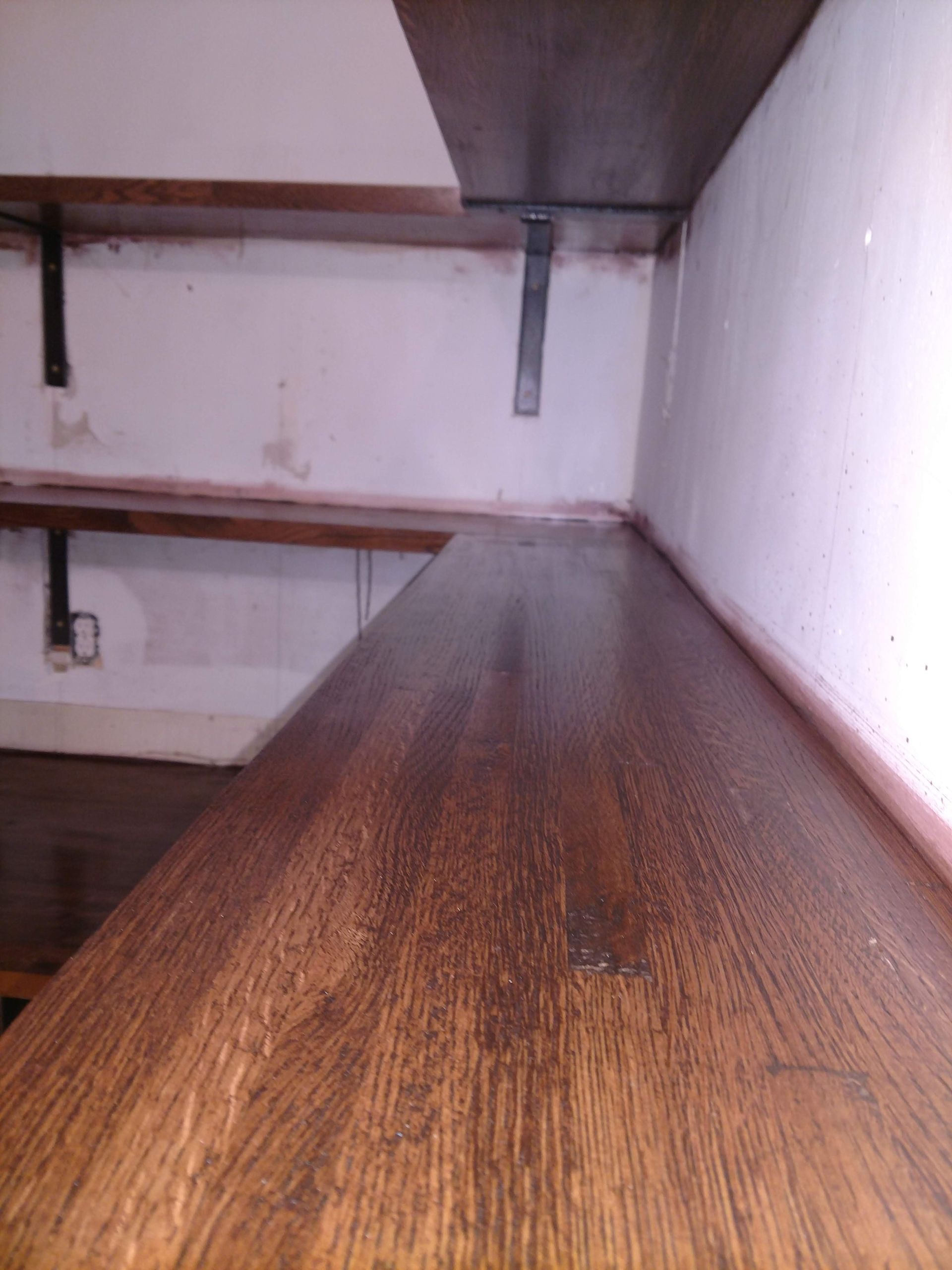 Wooden shelves with metal brackets against a white wall.