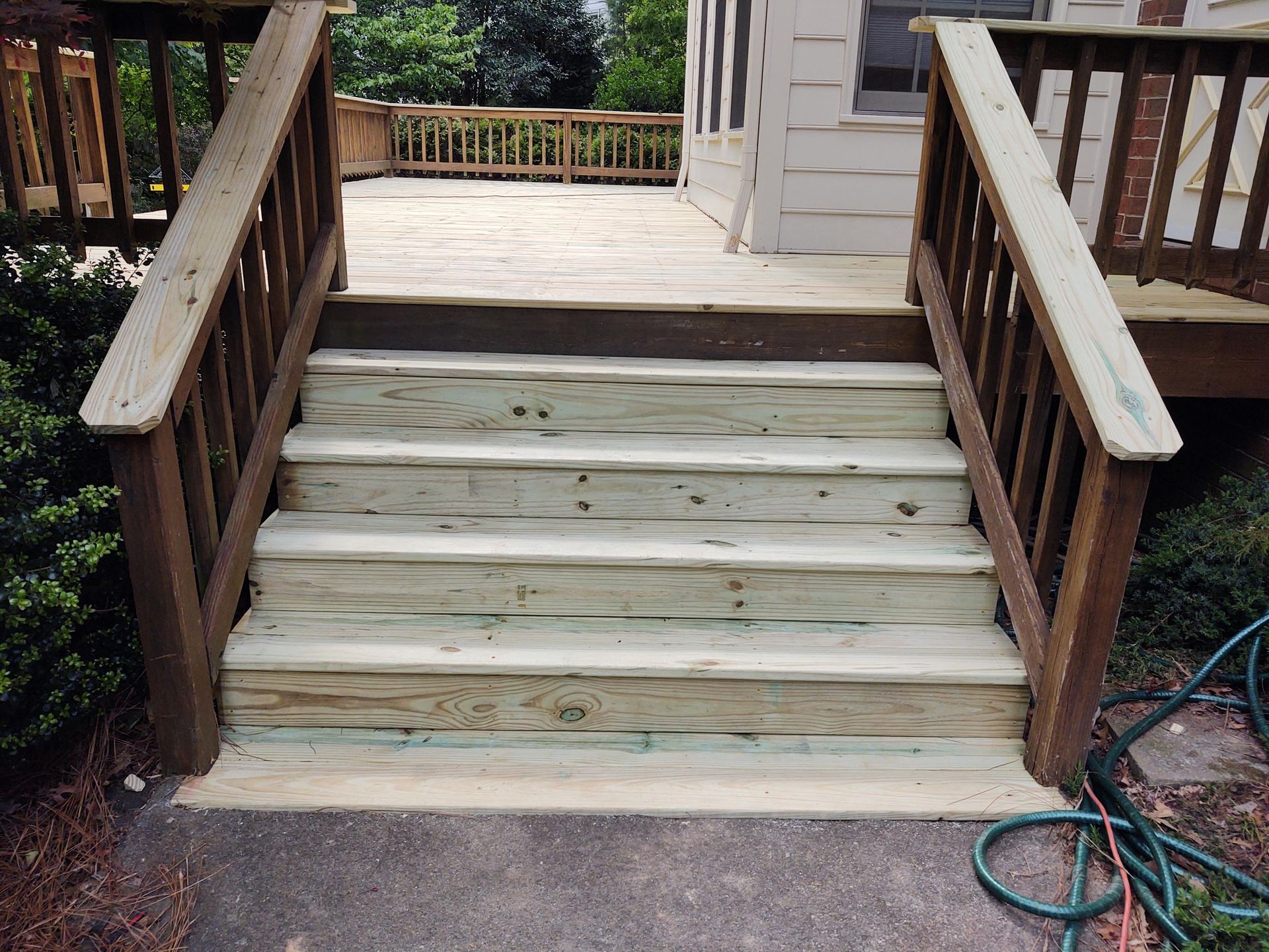 Wooden stairs leading up to a deck with railings.