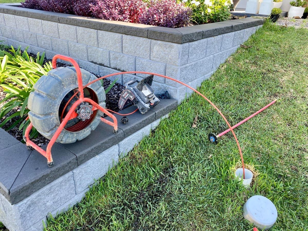 A drain camera is sitting on the side of a brick wall.