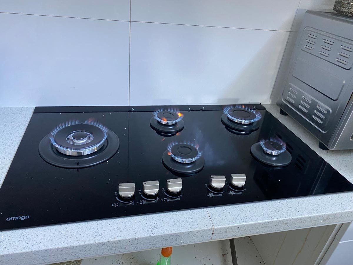 A gas stove is sitting on top of a counter in a kitchen.