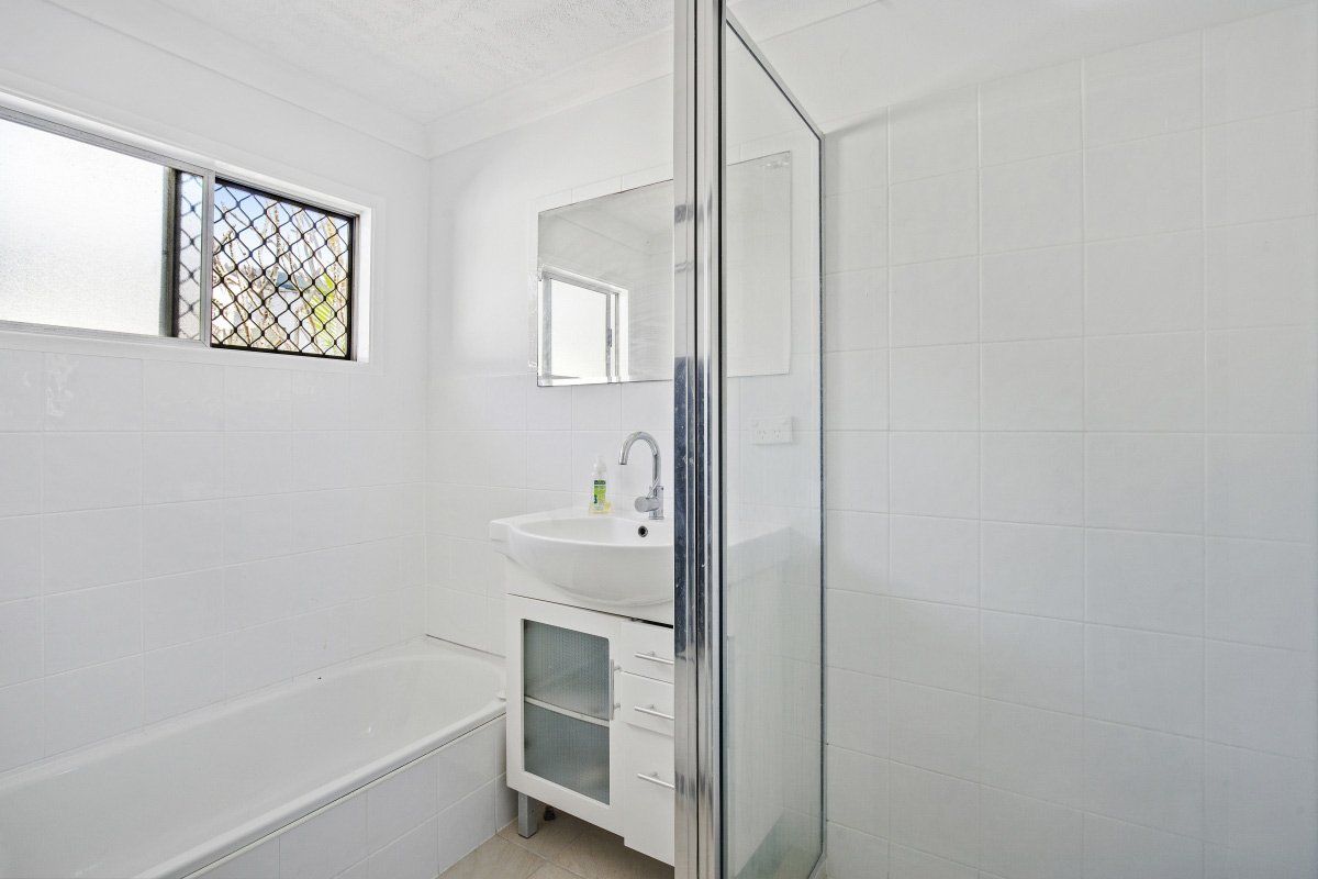 Bathroom With Bath Tub And Cabinet, Mirror And Bathroom Sink — Jones Building Group In Inverness, QLD