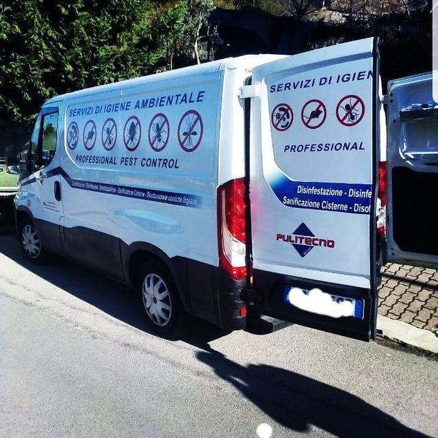 Furgone bianco per la disinfestazione con portiere posteriori aperte, parcheggiato su una strada. Include loghi e testi per la disinfestazione.