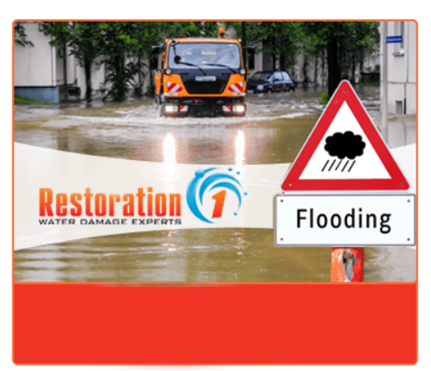 A truck is driving through a flooded street next to a flooding sign