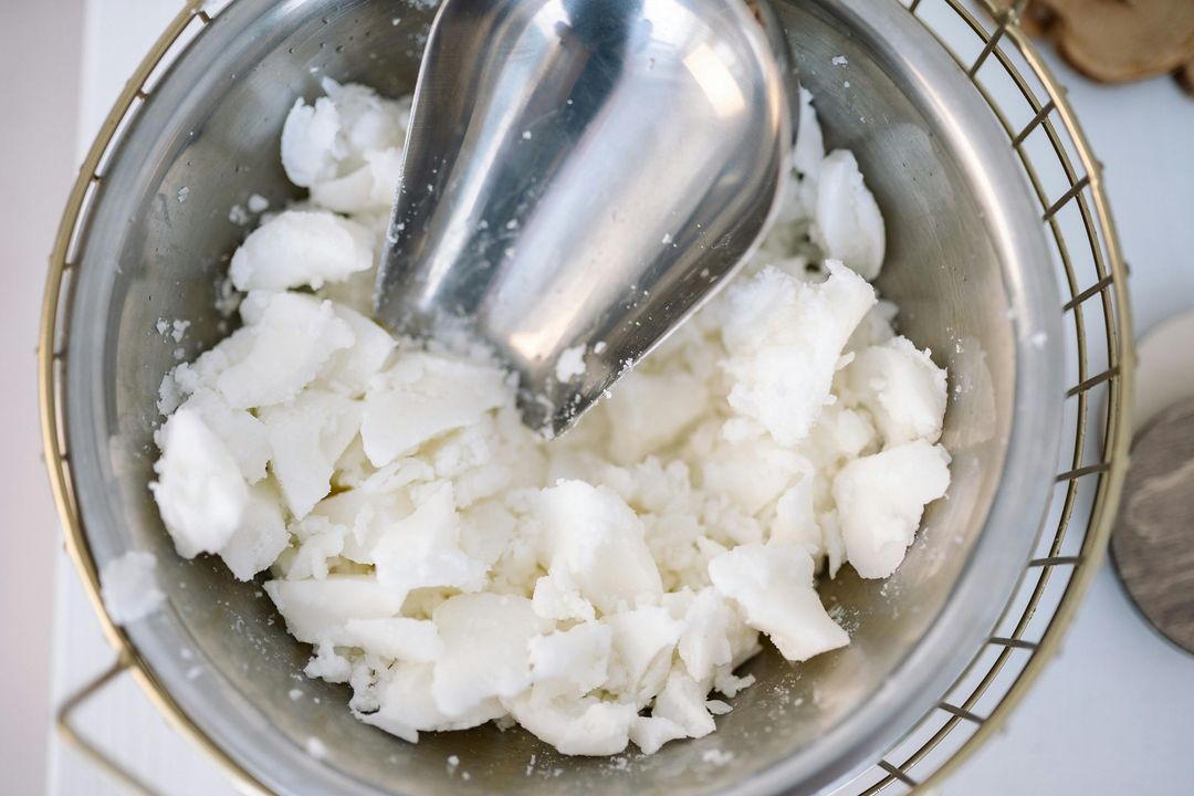 White, solid chunks of material in a metal bowl, a metal scoop inside.