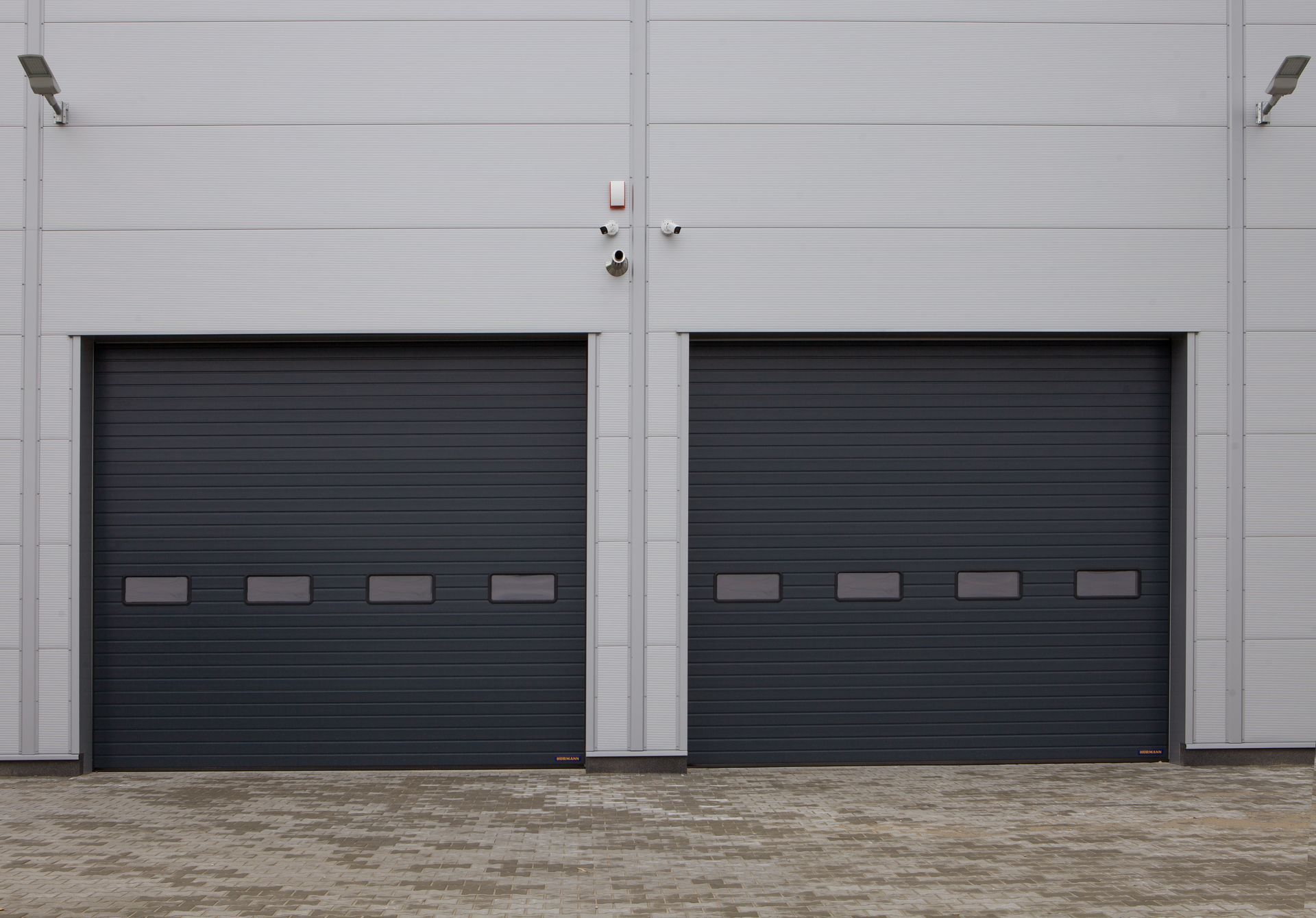Two dark commercial garage doors on an industrial building.