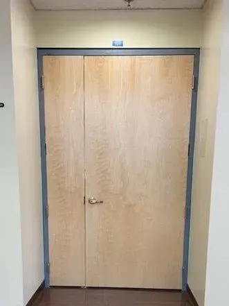 A wooden door with a blue trim is in a hallway.