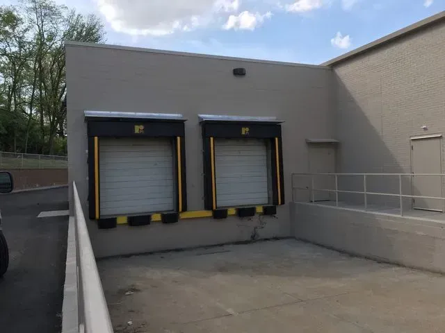 A truck is parked in front of a building with a ramp