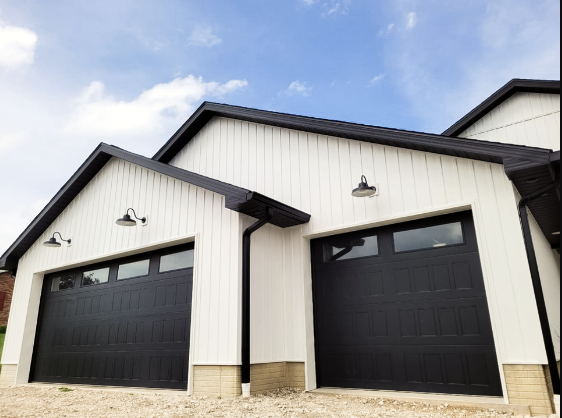 A gray garage door is sitting in front of a house.