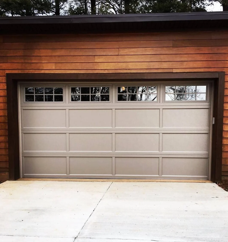 A large wooden barn with a large door and windows