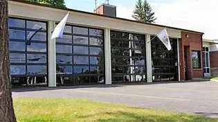 A large building with a lot of windows and a tree in front of it.