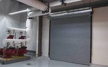 A room with a roller shutter door and pumps in it.