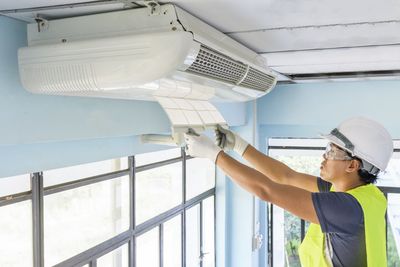 HVAC Technicians — Technician Repairing Air Conditioner in Port Lavaca, TX