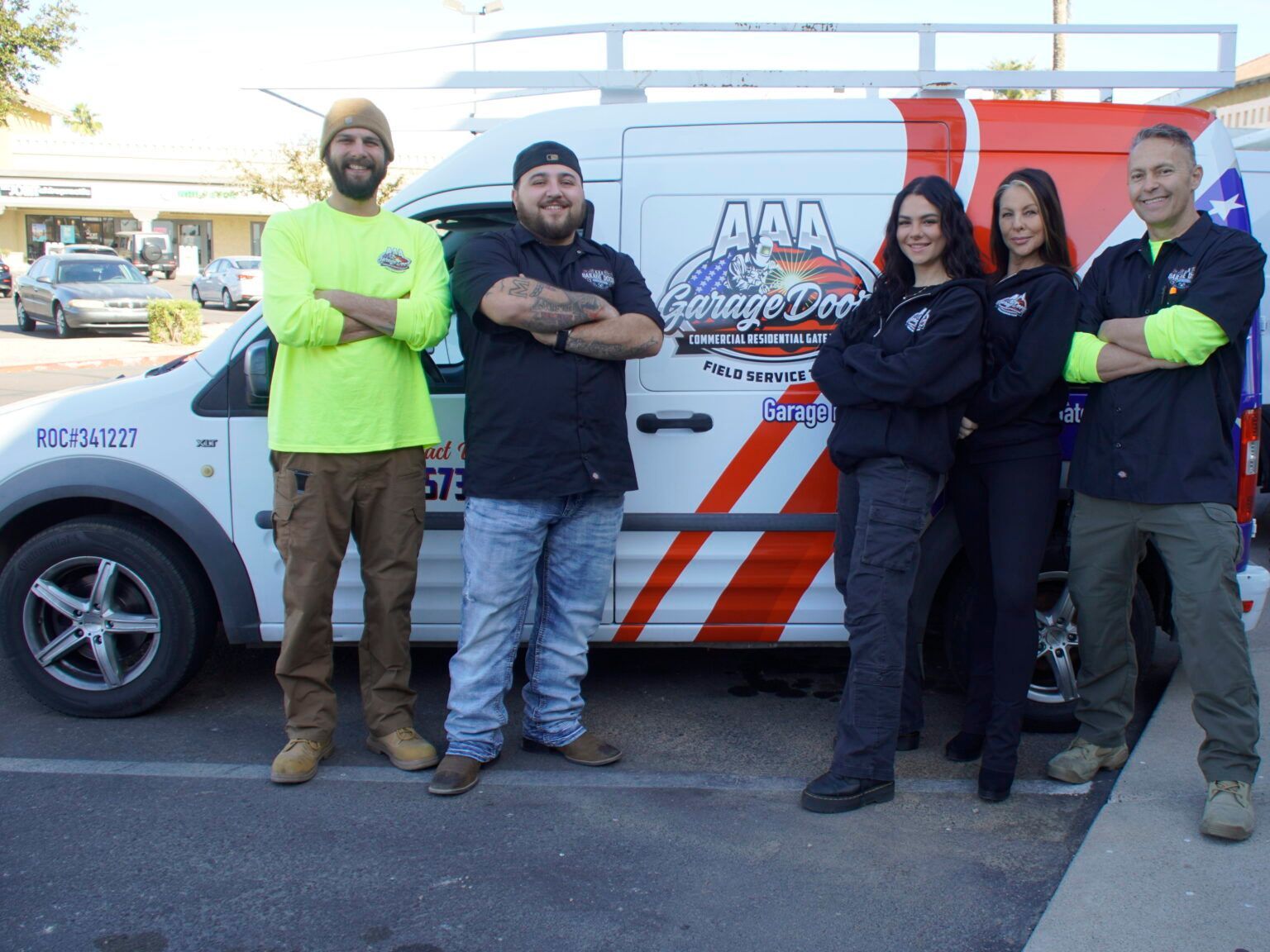 A group of people are posing for a picture in front of a van.