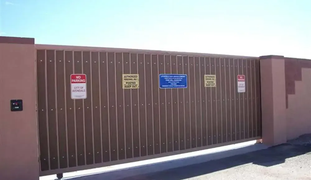 A sliding gate with warning signs on it