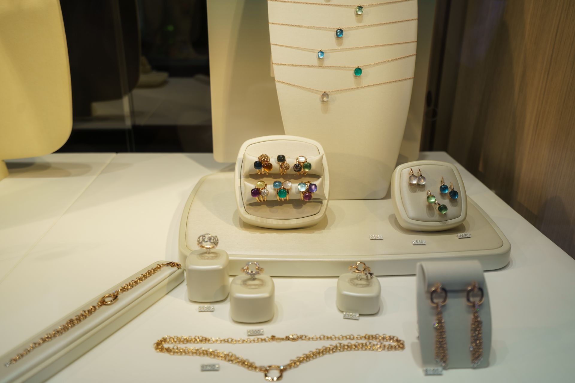 A display of jewelry on a table in a store window.