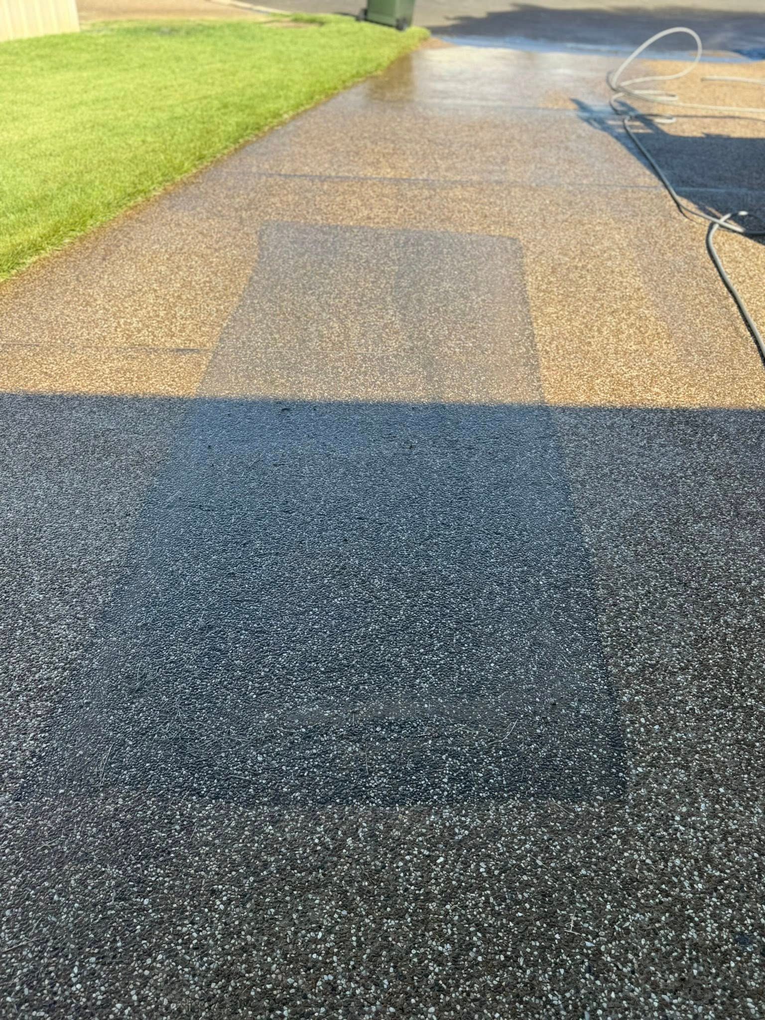 A Driveway With a Clear Visual Contrast Between a Dark — CPR Exterior Cleaning in Bundaberg North, QLD