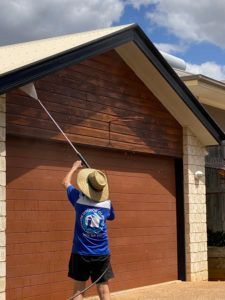 Worker Cleaning the Gutter of the Roof — CPR Exterior Cleaning in Svensson Heights, QLD
