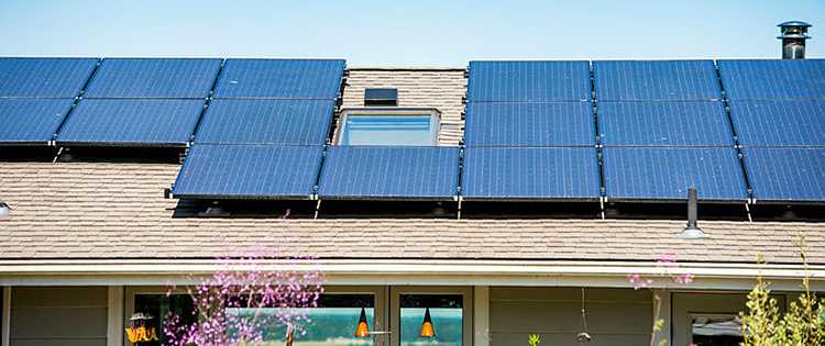 A house with a lot of solar panels on the roof.