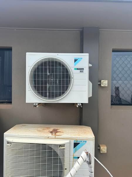 An Air Conditioner is Mounted on the Side of a Building — Eclipse Air Conditioning and Refrigeration in Trinity Beach, QLD