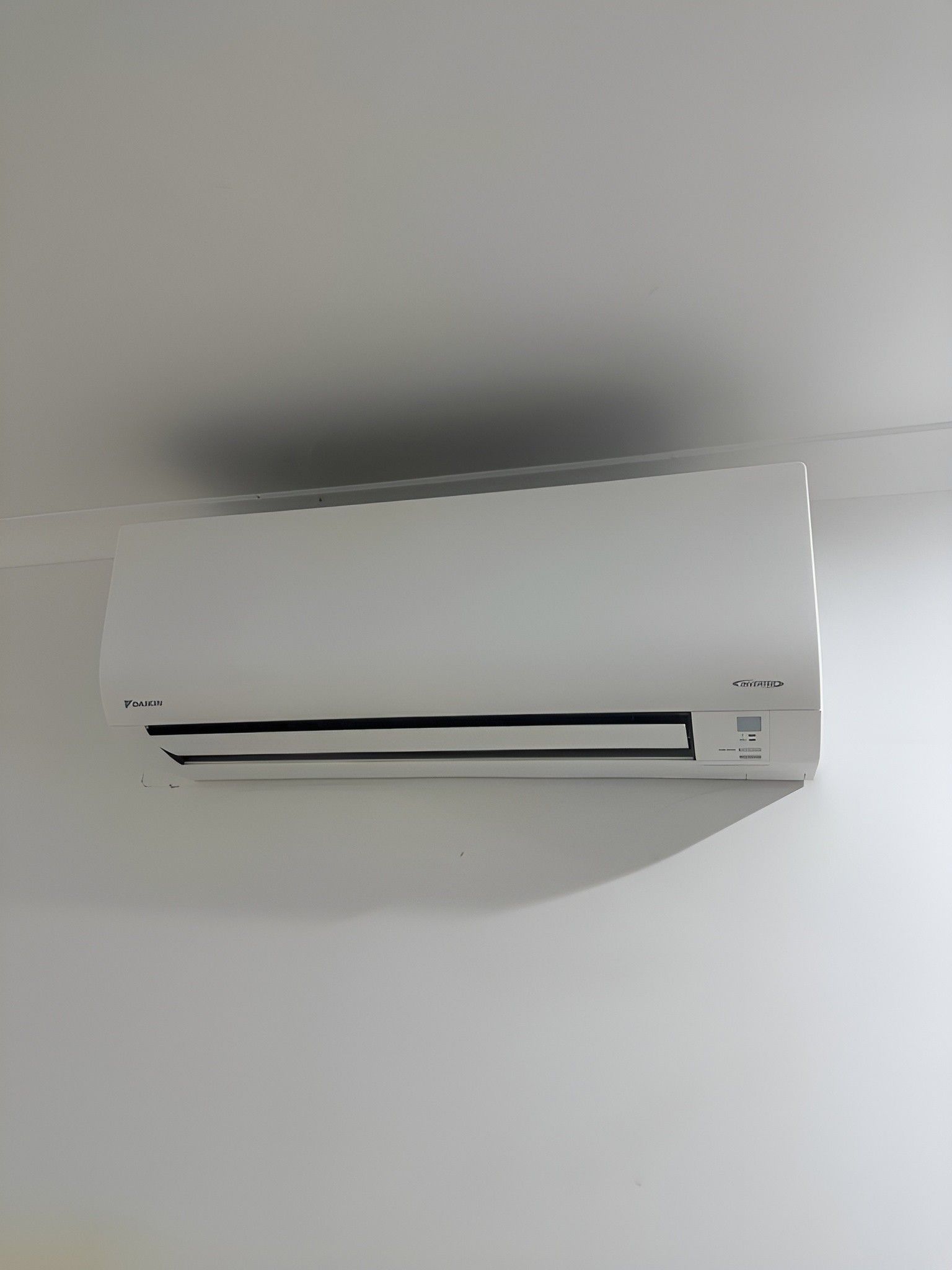 A White Air Conditioner is Hanging From the Ceiling in a Room — Eclipse Air Conditioning and Refrigeration in Trinity Beach, QLD