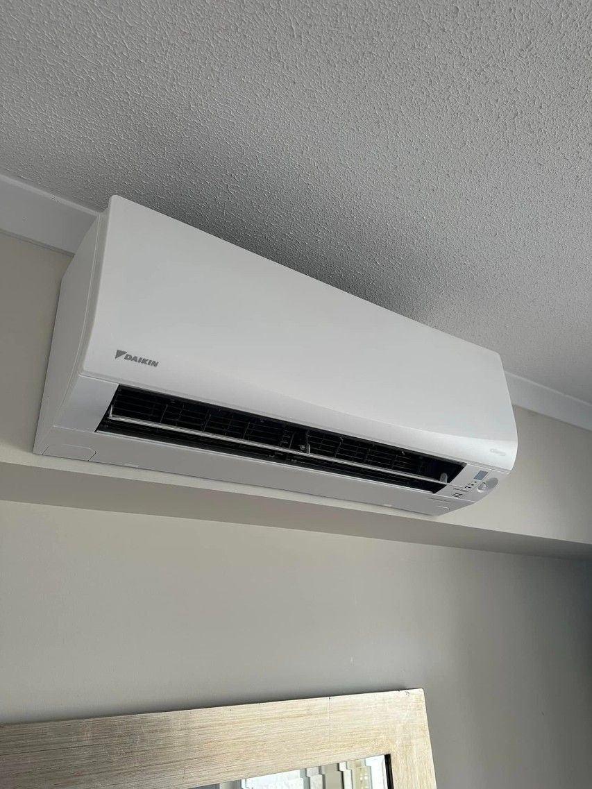 A White Air Conditioner is Hanging From the Ceiling in a Room — Eclipse Air Conditioning and Refrigeration in Trinity Beach, QLD