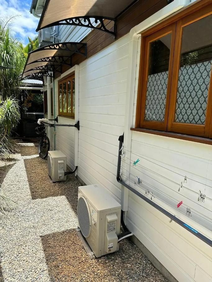 There Are Two Air Conditioners on the Side of a Building — Eclipse Air Conditioning and Refrigeration in Trinity Beach, QLD