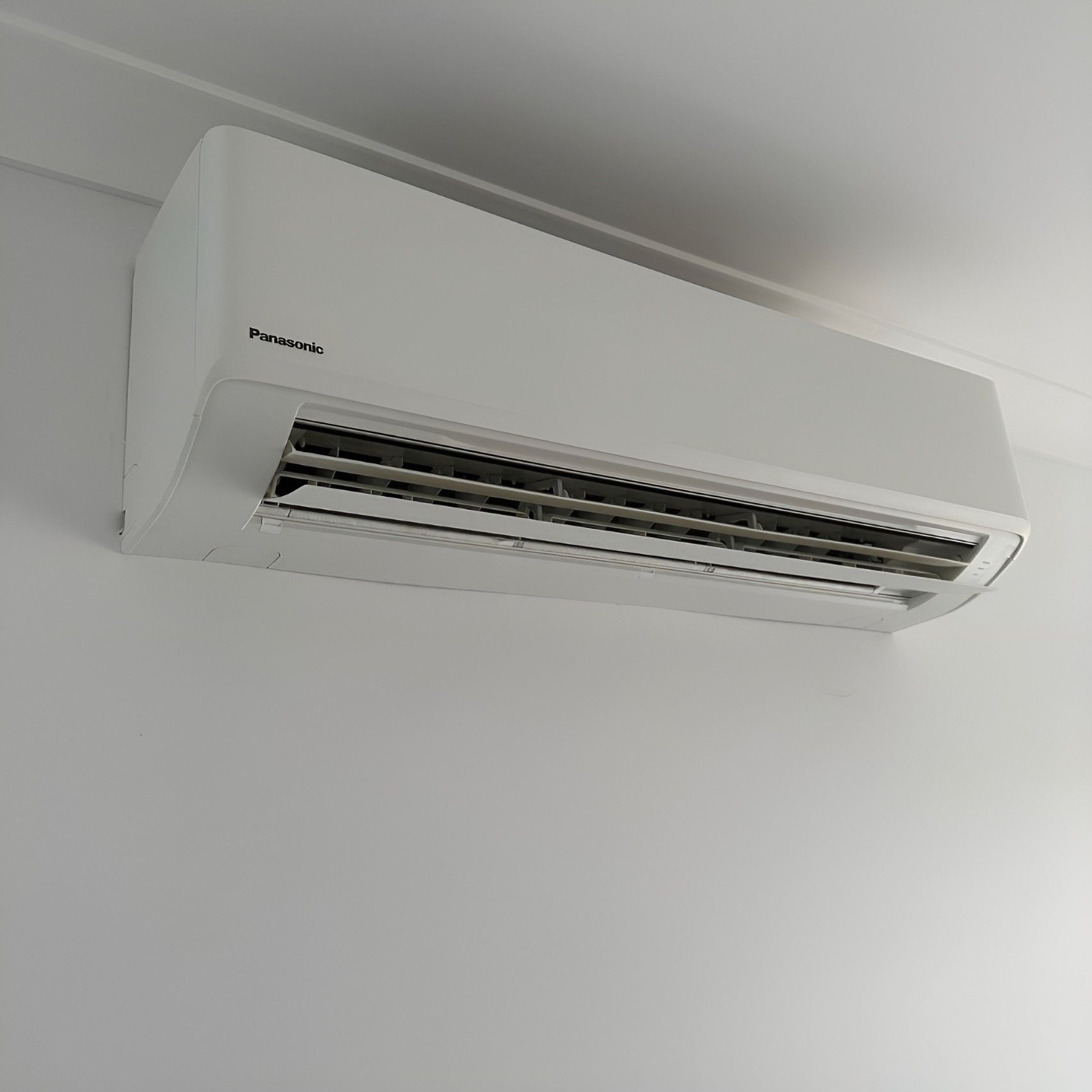 A White Air Conditioner is Hanging From the Ceiling in a Room — Eclipse Air Conditioning and Refrigeration In Palm Cove, QLD