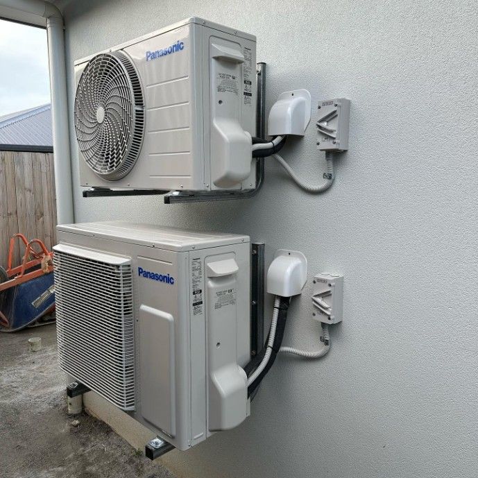 Two Air Conditioners Are Mounted on the Side of a Building — Eclipse Air Conditioning and Refrigeration In Palm Cove, QLD