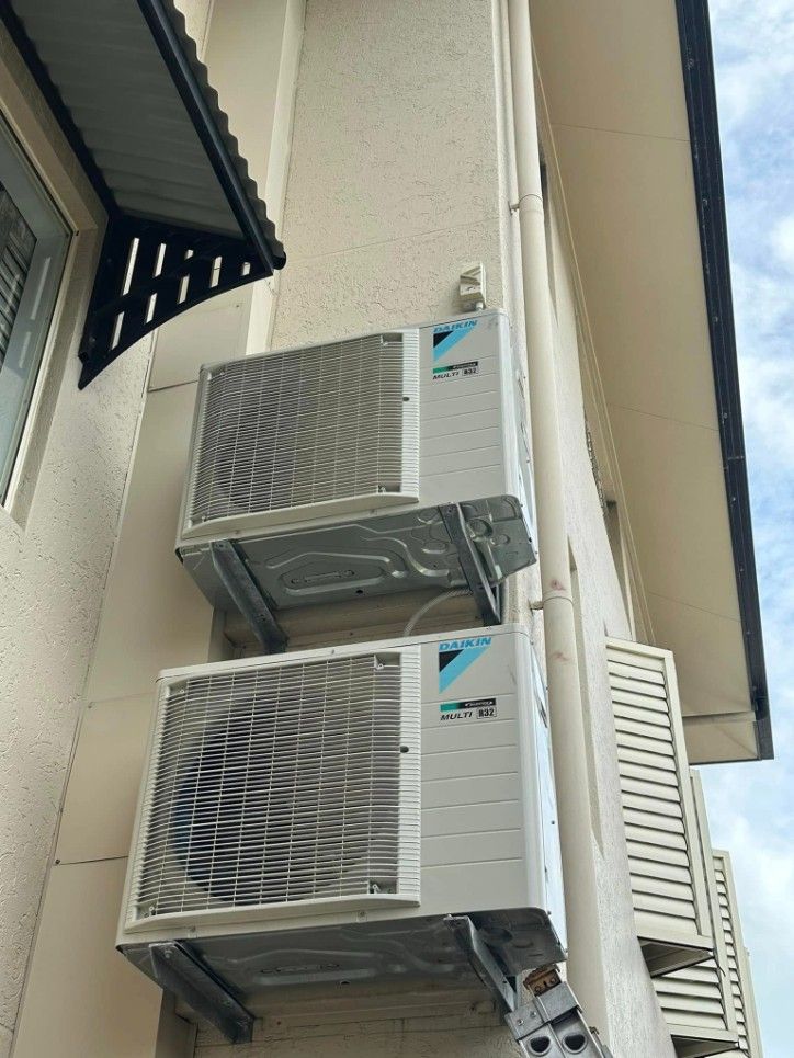 Two Air Conditioners Are Mounted on the Side of a Building — Eclipse Air Conditioning and Refrigeration In Smithfield, NSW