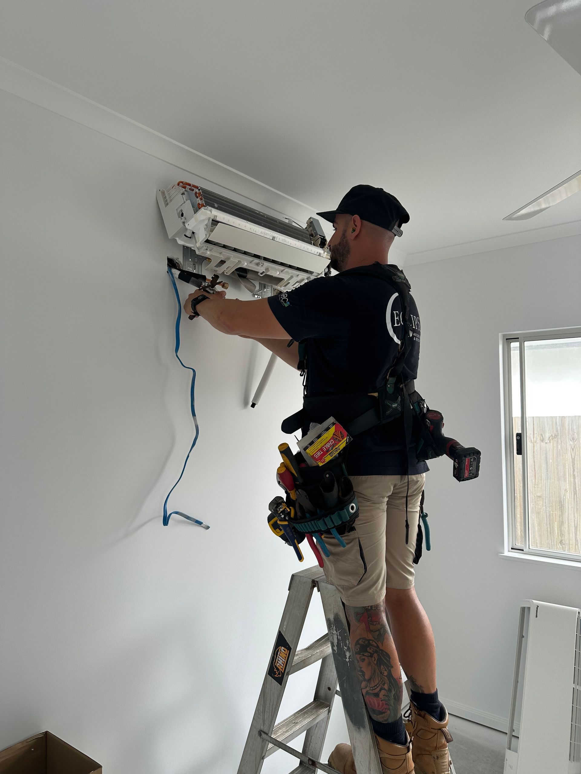 Man Installing a Air Conditioning Unit— Eclipse Air Conditioning and Refrigeration in Trinity Beach, QLD