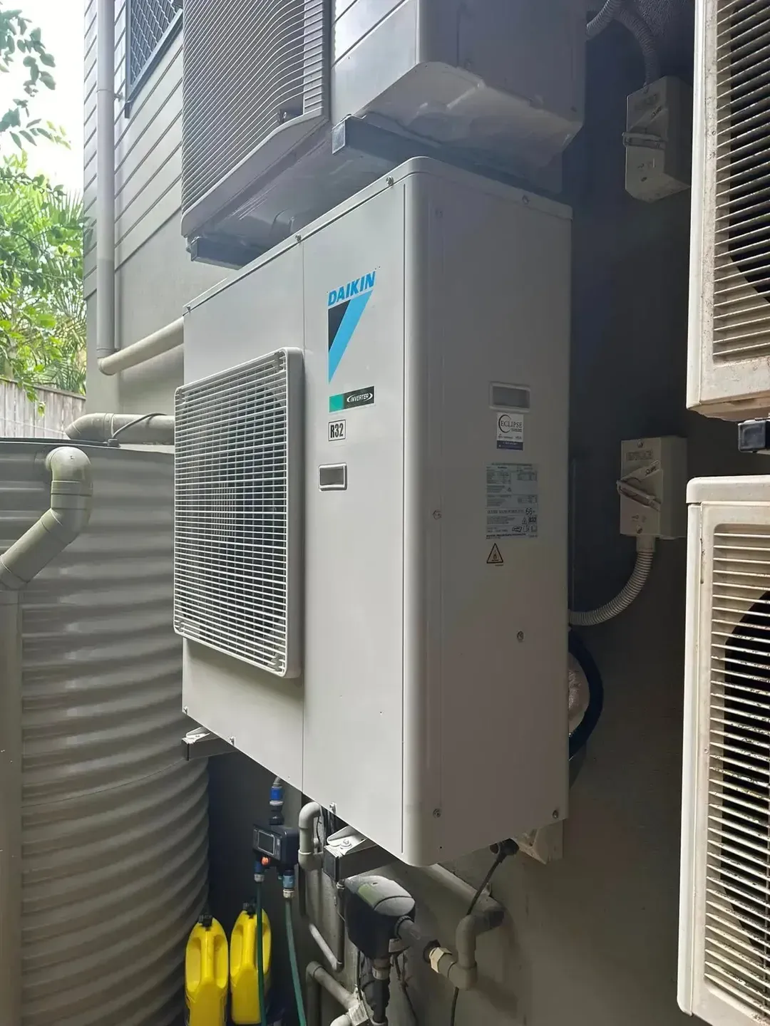 An Air Conditioner is Mounted on the Side of a Building — Eclipse Air Conditioning and Refrigeration in Trinity Beach, QLD