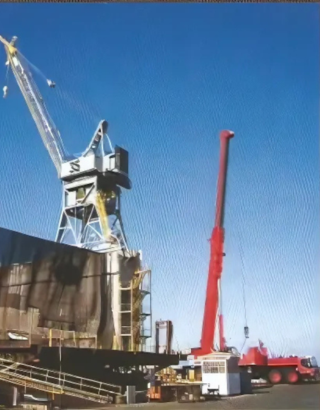 A large crane is sitting in front of a large building
