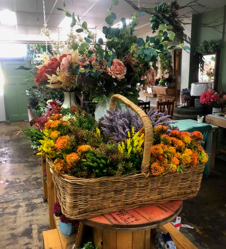 A Wicker Basket Filled with Flowers Sits on A Table — Fiori With Love in Ingham, QLD