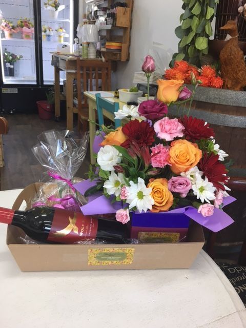 A Tray of Flowers and A Bottle of Wine on A Table — Fiori With Love in Ingham, QLD