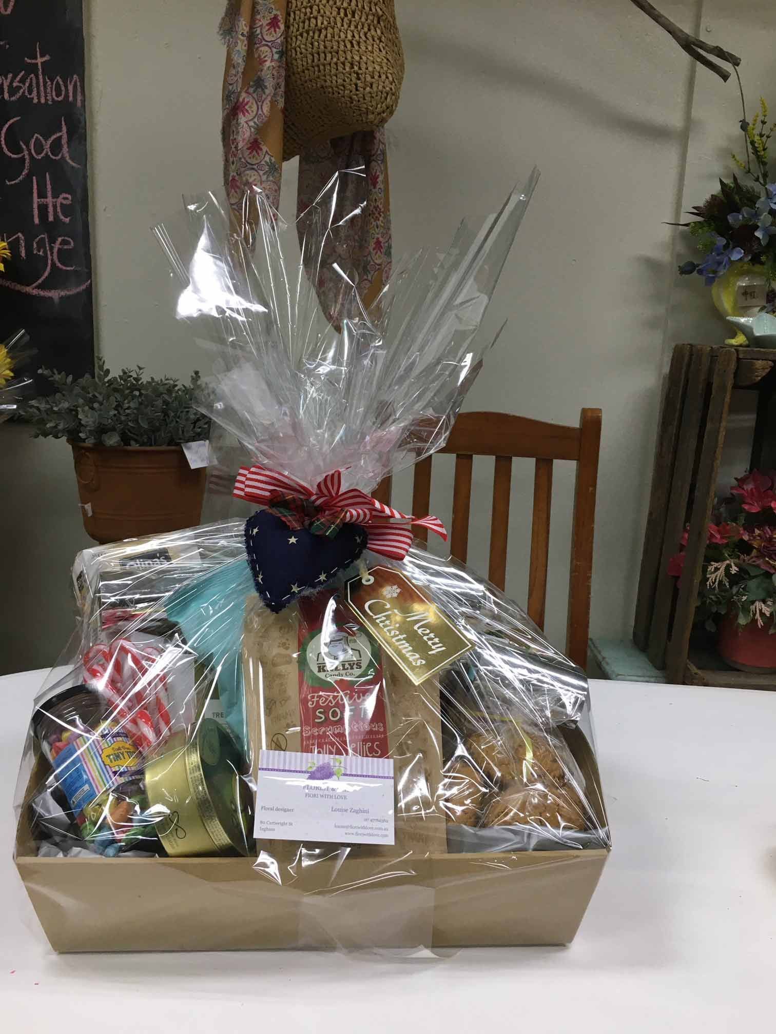 A Gift Basket Wrapped in Plastic Is Sitting on A Table — Fiori With Love in Ingham, QLD