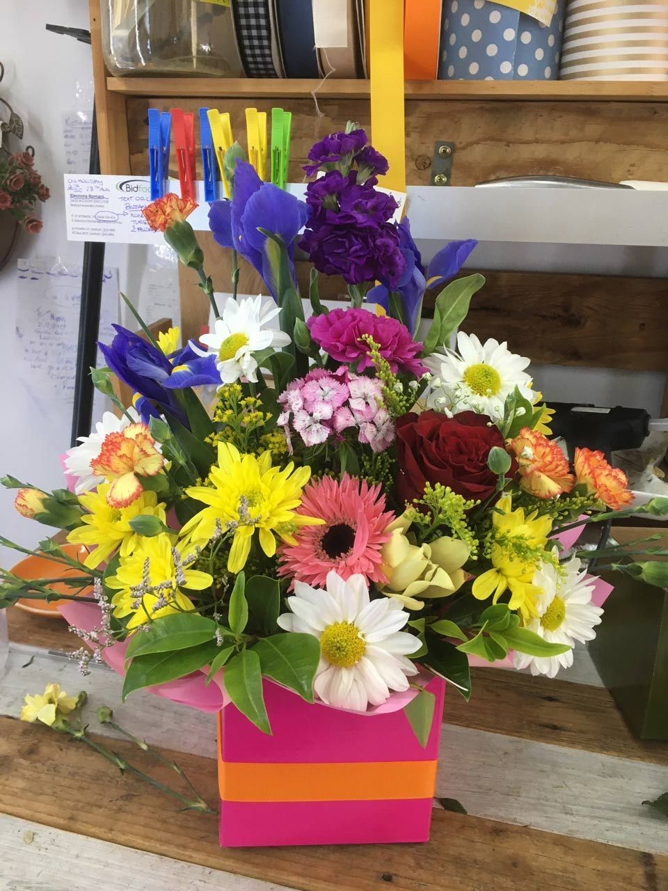 A Pink Box Filled with Flowers Sits on A Wooden Table — Fiori With Love in Ingham, QLD