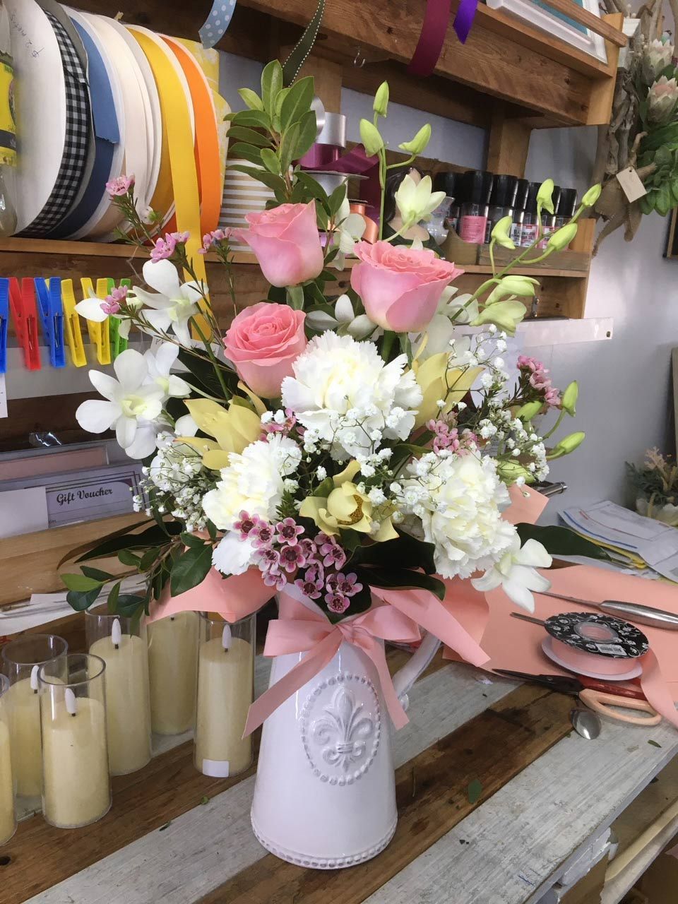 A Vase Filled with Flowers and Candles on A Table — Fiori With Love in Ingham, QLD