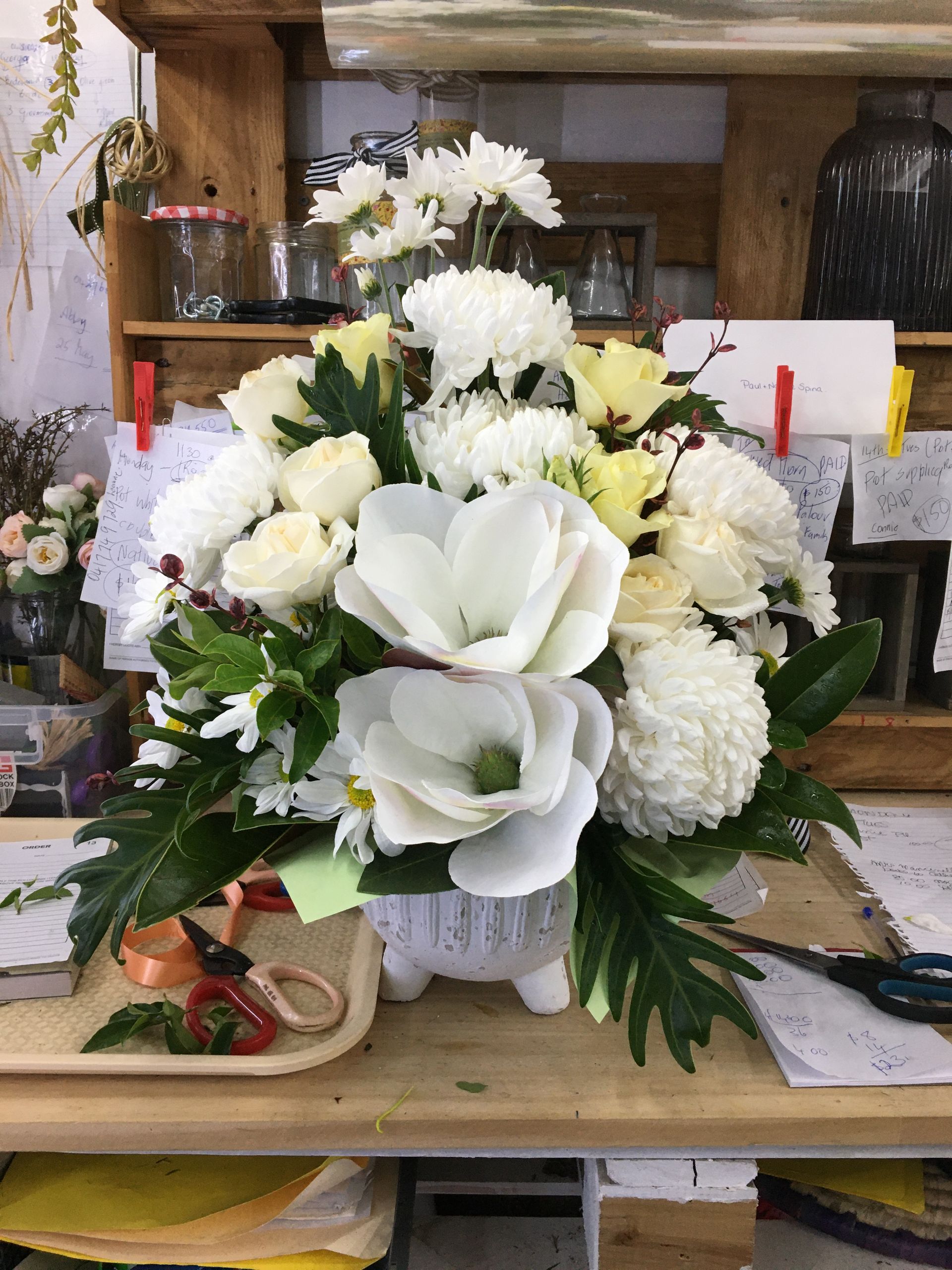 A Vase Filled with White Flowers Is Sitting on A Wooden Table — Fiori With Love in Ingham, QLD