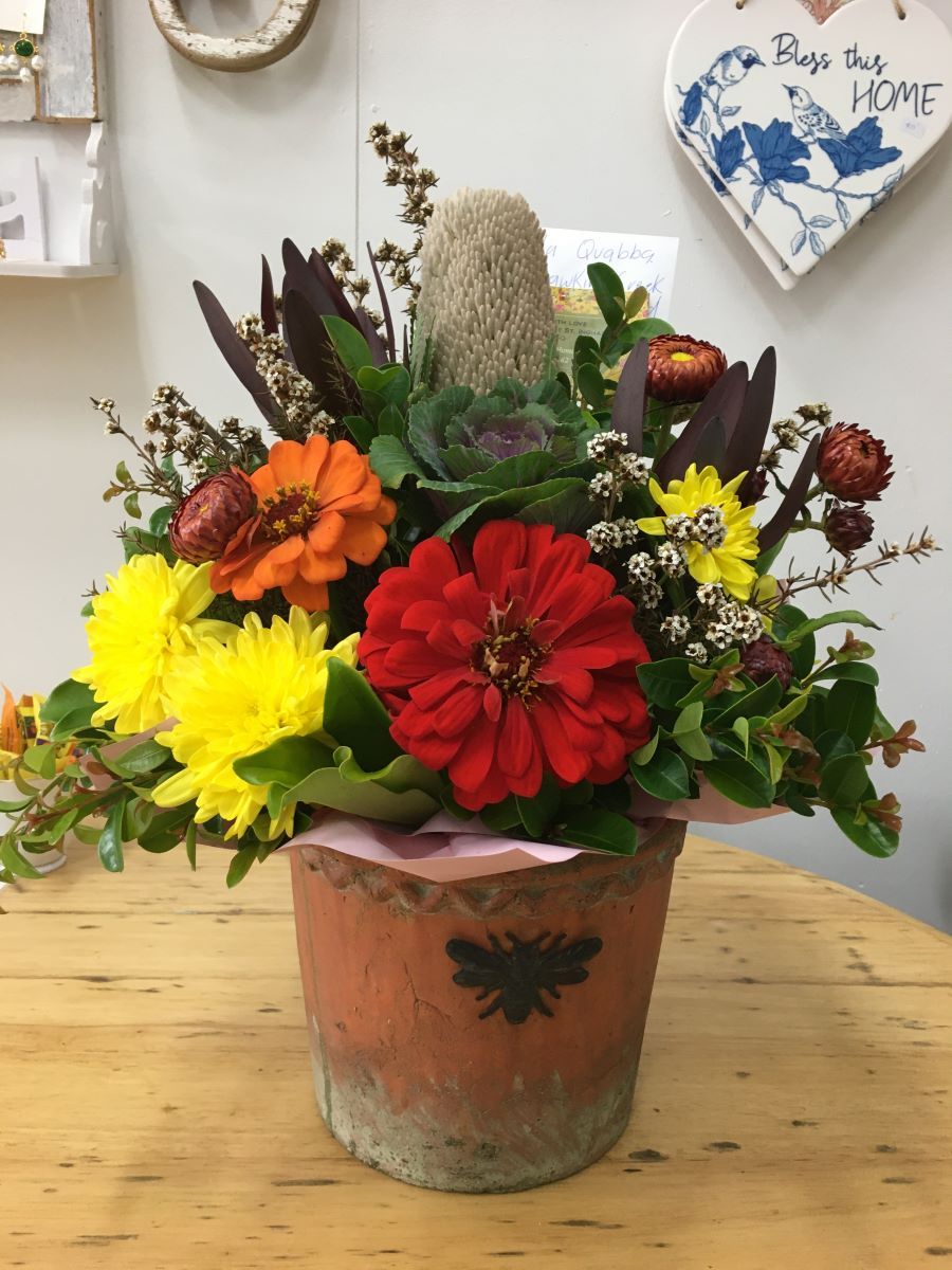 A Vase Filled with Flowers Is on A Wooden Table — Fiori With Love in Cardwell, QLD