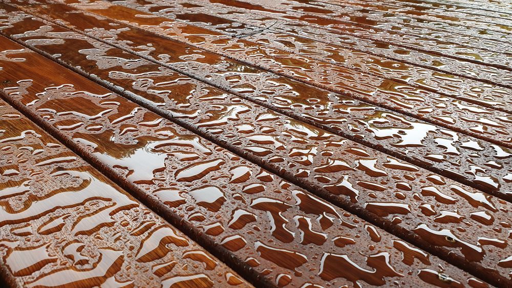 a close up of a wooden deck with water drops on it