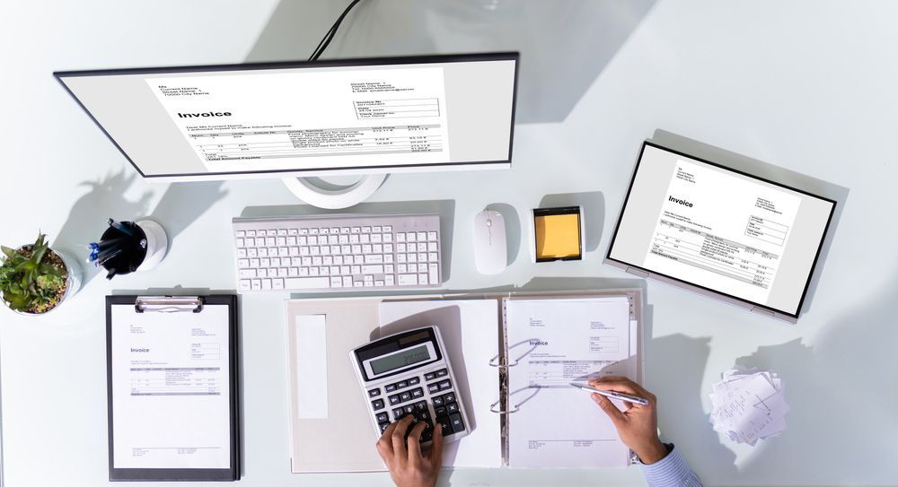 A Person is Sitting at a Desk Using a Calculator and a Computer — TJL Business Advisors and Accountants in  Forster, NSW