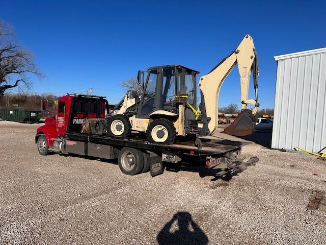 An excavator is being towed by a tow truck.