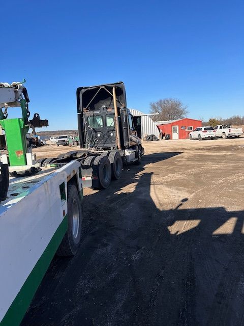A semi truck is being towed by a tow truck