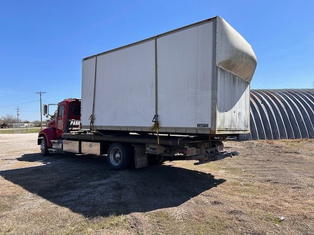 A red tow truck with a white box on top of it