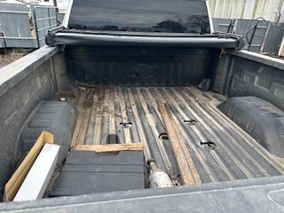 The back of a truck with a lot of wood in it.